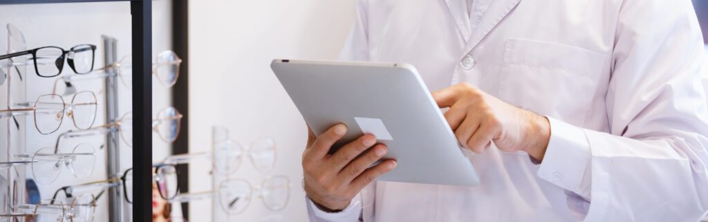 homem mexendo em tablet em frente a painel de oculos